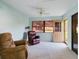 Cozy sunroom with plush carpet, leather chairs, and access to the exterior at 737 Bolivar St, The Villages, FL 32159