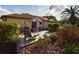 Inviting patio with outdoor seating, an umbrella, a grill, and well-maintained landscaping at 737 Bolivar St, The Villages, FL 32159