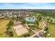 Aerial view of community amenities including pool, volleyball court, playground, recreation center, and walking paths at 831 Zeek Ridge Ct, Clermont, FL 34715