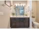 Bathroom with dual sinks, dark cabinets and a view into the glass enclosed shower at 831 Zeek Ridge Ct, Clermont, FL 34715