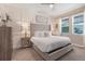 Comfortable bedroom featuring a neutral color scheme, tufted headboard, and plenty of natural light through two windows at 831 Zeek Ridge Ct, Clermont, FL 34715