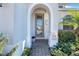 Elegant front entrance with a decorative glass door and meticulous landscaping at 831 Zeek Ridge Ct, Clermont, FL 34715