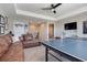 Carpeted game room with ping pong table, comfortable leather couch, and a wall mounted television at 831 Zeek Ridge Ct, Clermont, FL 34715