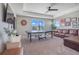 Spacious carpeted game room with ping pong table, a wall mounted television, and a comfortable leather couch at 831 Zeek Ridge Ct, Clermont, FL 34715