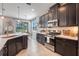 Beautiful kitchen with modern appliances, dark cabinetry, and adjacent dining area at 831 Zeek Ridge Ct, Clermont, FL 34715