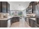 Bright kitchen boasts stainless steel appliances, dark cabinets, and an island with white countertop and open view to the backyard at 831 Zeek Ridge Ct, Clermont, FL 34715