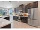 Beautiful kitchen features stainless steel appliances, dark cabinets, and an island with white countertop at 831 Zeek Ridge Ct, Clermont, FL 34715