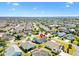 Wide aerial shot of a community showcasing well-kept homes with green lawns and mature trees at 909 Abaco Path, The Villages, FL 32163