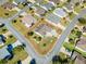 Bird's-eye view of a home with a circular driveway and stone-paved patio, surrounded by lush greenery at 909 Abaco Path, The Villages, FL 32163