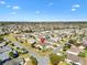 Expansive aerial view of a residential community featuring well-maintained lawns and mature palm trees at 909 Abaco Path, The Villages, FL 32163