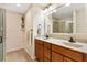 Bathroom with dual sinks, wooden cabinets, and glass shower at 909 Abaco Path, The Villages, FL 32163