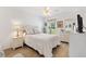 Inviting bedroom featuring a large window, light wood flooring and a comfortable bed at 909 Abaco Path, The Villages, FL 32163