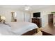 Primary bedroom with ceiling fan, TV, and ensuite bathroom at 909 Abaco Path, The Villages, FL 32163