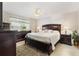 Spacious bedroom with a large window, ceiling fan, and dark wood furniture at 909 Abaco Path, The Villages, FL 32163