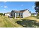 Charming single-story home with manicured lawn, sunroom, and lush landscaping at 909 Abaco Path, The Villages, FL 32163