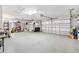 Spacious garage with multiple doors, epoxy floor, shelving, and ample storage at 909 Abaco Path, The Villages, FL 32163