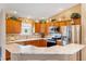 Well-lit kitchen featuring wooden cabinets, stainless steel appliances, and light countertops at 909 Abaco Path, The Villages, FL 32163