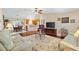 Spacious living room featuring hardwood floors, a ceiling fan, and an open layout to the dining area at 909 Abaco Path, The Villages, FL 32163