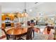 Open-concept living space with hardwood floors and clear view of kitchen, dining, and living rooms at 909 Abaco Path, The Villages, FL 32163