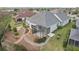 Aerial view of the backyard with landscaping, a stone pathway, a screened-in lanai, and green grass at 960 Pickering Path, The Villages, FL 32163
