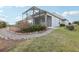 A beautiful backyard with a screened-in lanai, lush landscaping, and a charming stone pathway at 960 Pickering Path, The Villages, FL 32163