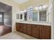 Bathroom with double vanity, stone tile floors, and access to a stand-up shower and linen closet at 960 Pickering Path, The Villages, FL 32163