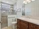 Bathroom with walk-in shower, grab bar, single sink vanity, and neutral color palette at 960 Pickering Path, The Villages, FL 32163