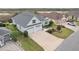 Aerial view of a well-maintained home with a two-car garage, green lawn, and landscaped front yard at 960 Pickering Path, The Villages, FL 32163