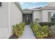 Inviting front entrance featuring a walkway lined with lush landscaping leading to a screen door at 960 Pickering Path, The Villages, FL 32163