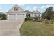 Charming one-story home featuring a well-manicured lawn, landscaping, and a two-car garage at 960 Pickering Path, The Villages, FL 32163