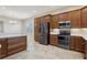 Kitchen featuring stainless steel appliances, wood cabinets, and an adjacent breakfast bar area at 960 Pickering Path, The Villages, FL 32163