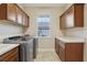 Bright laundry room with modern washer and dryer, cabinetry, and a sink at 960 Pickering Path, The Villages, FL 32163