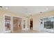 Bright living room features neutral color scheme, tile floors, ceiling fan, and access to other rooms and outdoor space at 960 Pickering Path, The Villages, FL 32163