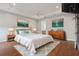 Spacious main bedroom suite features tray ceilings, hardwood floors, elegant furnishings, and ensuite bathroom at 960 Pickering Path, The Villages, FL 32163