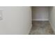 Hallway with gray tile flooring showing access to a storage area and a light switch at 960 Pickering Path, The Villages, FL 32163