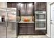 Kitchen area featuring stainless steel refrigerator, double ovens, dark cabinetry, and mosaic backsplash at 9605 Lynwood St, Clermont, FL 34711