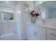 Bright bathroom featuring white cabinetry, double sinks, and a decorative flower arrangement at 998 Sayle St, The Villages, FL 32162