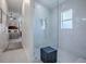 Elegant bathroom with a glass-enclosed shower and sleek white marble tiling at 998 Sayle St, The Villages, FL 32162