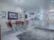 Open-concept dining area with stylish chairs, glass table, and elegant chandelier at 998 Sayle St, The Villages, FL 32162