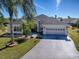 Well-maintained home featuring mature landscaping, a spacious driveway, and a two-car garage at 998 Sayle St, The Villages, FL 32162