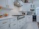 Updated kitchen featuring white cabinetry, stainless steel appliances, and herringbone backsplash at 998 Sayle St, The Villages, FL 32162