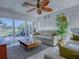 Inviting living room with comfortable seating, access to a patio, and leafy ceiling fan at 998 Sayle St, The Villages, FL 32162