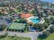 Panoramic aerial view of a community showcasing amenities, including tennis courts and a resort-style pool at 10105 Ketch Kay Ln, Oxford, FL 34484