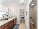 Bathroom with double sink vanity and a view of the toilet and bedroom at 10105 Ketch Kay Ln, Oxford, FL 34484