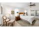 Cozy bedroom with a wooden headboard, ceiling fan, and a window with natural light at 10105 Ketch Kay Ln, Oxford, FL 34484