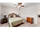 Cozy bedroom features a ceiling fan, plush carpet, and warm natural light at 10105 Ketch Kay Ln, Oxford, FL 34484