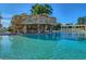 Stunning pool area with a rock waterfall feature, clear blue water, and ample seating at 10105 Ketch Kay Ln, Oxford, FL 34484