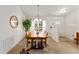 Cozy dining area featuring a wooden table, chandelier lighting, and a view of the well-maintained backyard at 10105 Ketch Kay Ln, Oxford, FL 34484