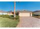 Charming single-story home featuring a paver driveway, manicured lawn, and a two-car garage at 10105 Ketch Kay Ln, Oxford, FL 34484