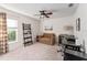 Cozy home office features neutral carpet, ceiling fan, sleeper sofa, and black computer desk for an ideal work environment at 10105 Ketch Kay Ln, Oxford, FL 34484